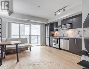 Toronto (Yonge-Eglinton) condo for rent - A modern kitchen with a dining table and a view of the city.
