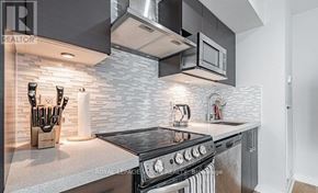 Toronto (Yonge-Eglinton) condo for rent - A modern kitchen with a black stove top oven and a microwave above it.