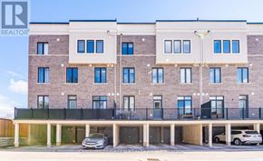 Hamilton (Waterdown) townhouse for rent - A multi-story brick building with a balcony and a car parked in front.