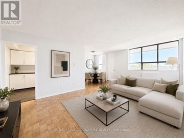 Toronto (Mount Pleasant East) house for rent - A living room with a white couch, a coffee table, and a large window.