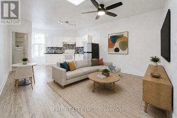 Toronto (Weston-Pellam Park) duplex for rent - A living room with a white couch, a wooden coffee table, and a ceiling fan.
