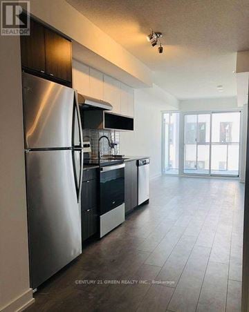 Burlington (Lasalle) condo for rent - A kitchen with a stainless steel refrigerator and black countertops.