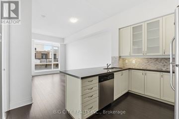 Markham (Unionville) condo for rent - A kitchen with white cabinets and a black countertop.
