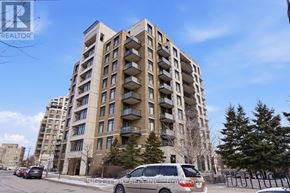 Markham (Unionville) condo for rent - A tall apartment building with a car parked in front of it.