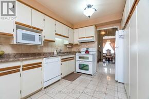 Mississauga (Lorne Park) apartment for rent - A kitchen with white appliances and wooden cabinets.