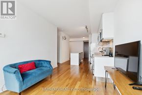 Toronto (Bay Street Corridor) condo for rent - A blue couch with a red pillow is in the living room.