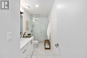 Cobourg triplex for rent - A white bathroom with a glass shower stall and a white toilet.