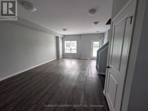 Welland (Broadway) townhouse for rent - A room with wooden flooring and white walls, with a door on the right side.
