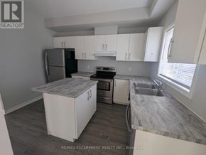 Welland (Broadway) townhouse for rent - A kitchen with a refrigerator, oven, and sink.