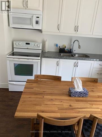 Newmarket (Woodland Hill) apartment for rent - A kitchen with a wooden table and white cabinets.