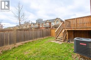 Oakville (Jm Joshua Meadows) townhouse for rent - A backyard with a fence and a heat pump.