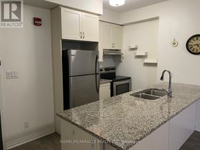 Markham (Cornell) condo for rent - A kitchen with granite countertops and a refrigerator.