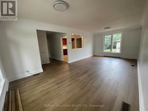 Richmond Hill (Crosby) apartment for rent - A room with wooden flooring and a window showing greenery outside.