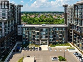 Waterdown condo for rent - A large building with a parking lot in front of it.