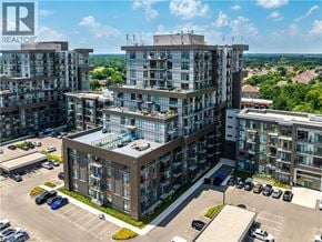 Waterdown condo for rent - A large building complex with a parking lot in front.