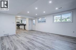 Welland (West Welland) apartment for rent - A spacious room with wood flooring and white walls.