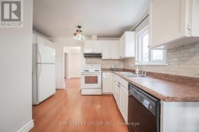 Oshawa (Eastdale) apartment for rent - A kitchen with white appliances and wooden floors.