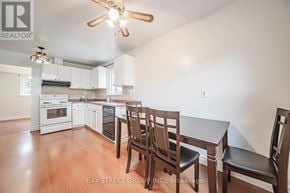 Oshawa (Eastdale) apartment for rent - A kitchen with white cabinets and a wooden table with chairs.