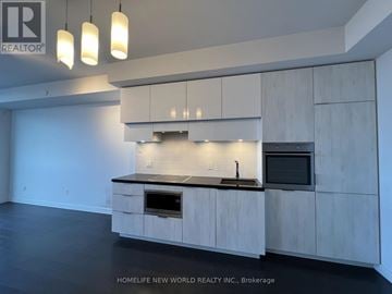 Toronto (Mount Pleasant West) condo for rent - A modern kitchen with white cabinets and a black countertop.
