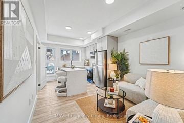 Niagara Falls (Arad/Fallsview) townhouse for rent - A well-lit, modern living room with a glass coffee table and a grey sofa.