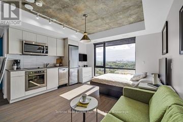 Ottawa condo for rent - A modern kitchen with a green couch in the living room.