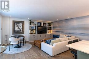 Ottawa condo for rent - A living room with a white sofa, a black chair, and a television.