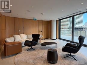 Toronto (Bay Street Corridor) condo for rent - A living room with a brown couch, two black chairs, and a round table.