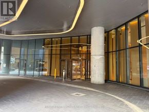 Toronto (Bay Street Corridor) condo for rent - The image shows the entrance to a building with glass doors and a pillar in front.