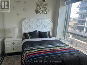 Toronto (Banbury-Don Mills) condo for rent - A bedroom with a large bed and a chandelier.