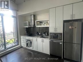 Toronto (Banbury-Don Mills) condo for rent - A modern kitchen with stainless steel appliances and white cabinets.
