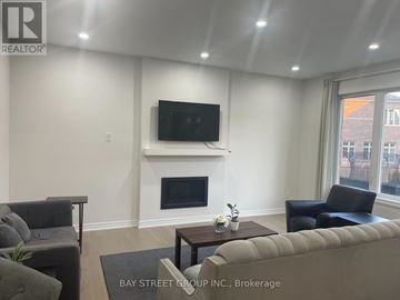 Georgina (Keswick South) apartment for rent - A living room with a fireplace and a flat screen TV mounted above it.