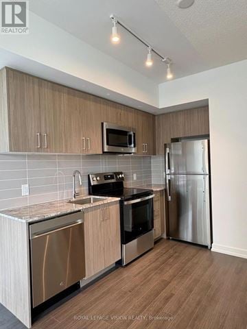 Toronto (Humber Heights) condo for rent - A kitchen with wooden cabinets and stainless steel appliances.