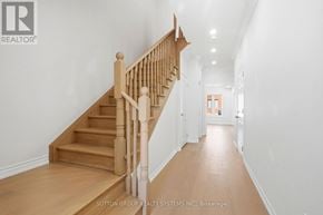 Thorold (Thorold Downtown) townhouse for rent - A hallway with a staircase and a brokerage logo.