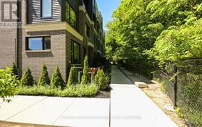 Mississauga (Erin Mills) townhouse for rent - A residential street with a house on the left and a sidewalk.