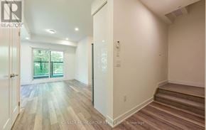 Mississauga (Erin Mills) townhouse for rent - A room with wooden flooring and a staircase leading to another room.