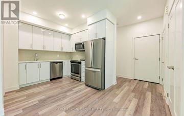 Mississauga (Erin Mills) townhouse for rent - A kitchen with white cabinets and a wooden floor.