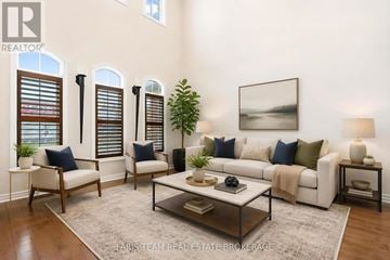 Barrie (Innis-Shore) apartment for rent - A living room with a white couch, a coffee table, and a painting on the wall.