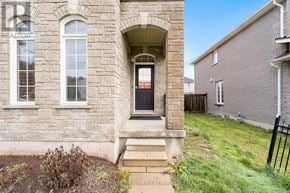 Barrie (Innis-Shore) apartment for rent - A stone building with a black door and a sign that says REALTOR.