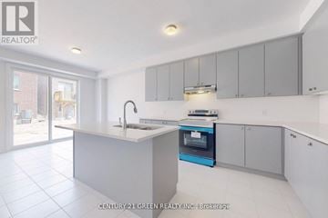 Oshawa (Kedron) apartment for rent - A kitchen with white cabinets and a blue oven.