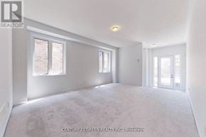 Oshawa (Kedron) apartment for rent - A spacious room with a carpeted floor and white walls.