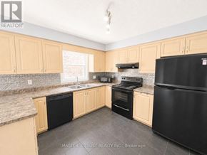 Kitchener apartment for rent - A kitchen with black appliances and wooden cabinets.