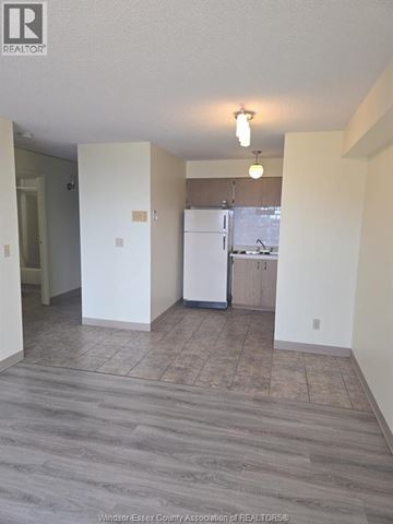 Windsor condo for rent - A kitchen area with a refrigerator, sink, and cabinets.