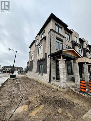 Cambridge townhouse for rent - A modern house under construction with a grey and black exterior.