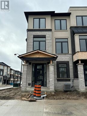 Cambridge townhouse for rent - A house under construction with a grey and brown exterior.