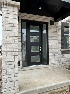 Cambridge townhouse for rent - A black door is set in a stone wall.