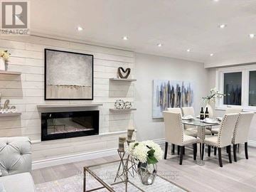 Whitchurch-Stouffville (Stouffville) apartment for rent - A modern living room with a fireplace and a dining table set up.