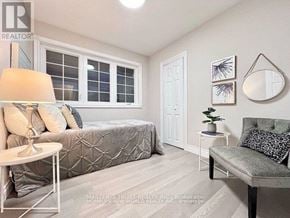 Whitchurch-Stouffville (Stouffville) apartment for rent - A bedroom with a bed, a couch, a table, and a window.