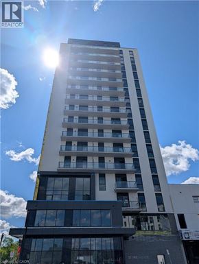 Brantford condo for rent - A tall building with a sun shining in the sky.