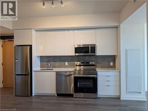 Brantford condo for rent - A modern kitchen with white cabinets and stainless steel appliances.