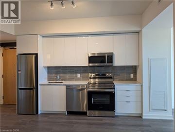 Brantford condo for rent - A modern kitchen with white cabinets and stainless steel appliances.